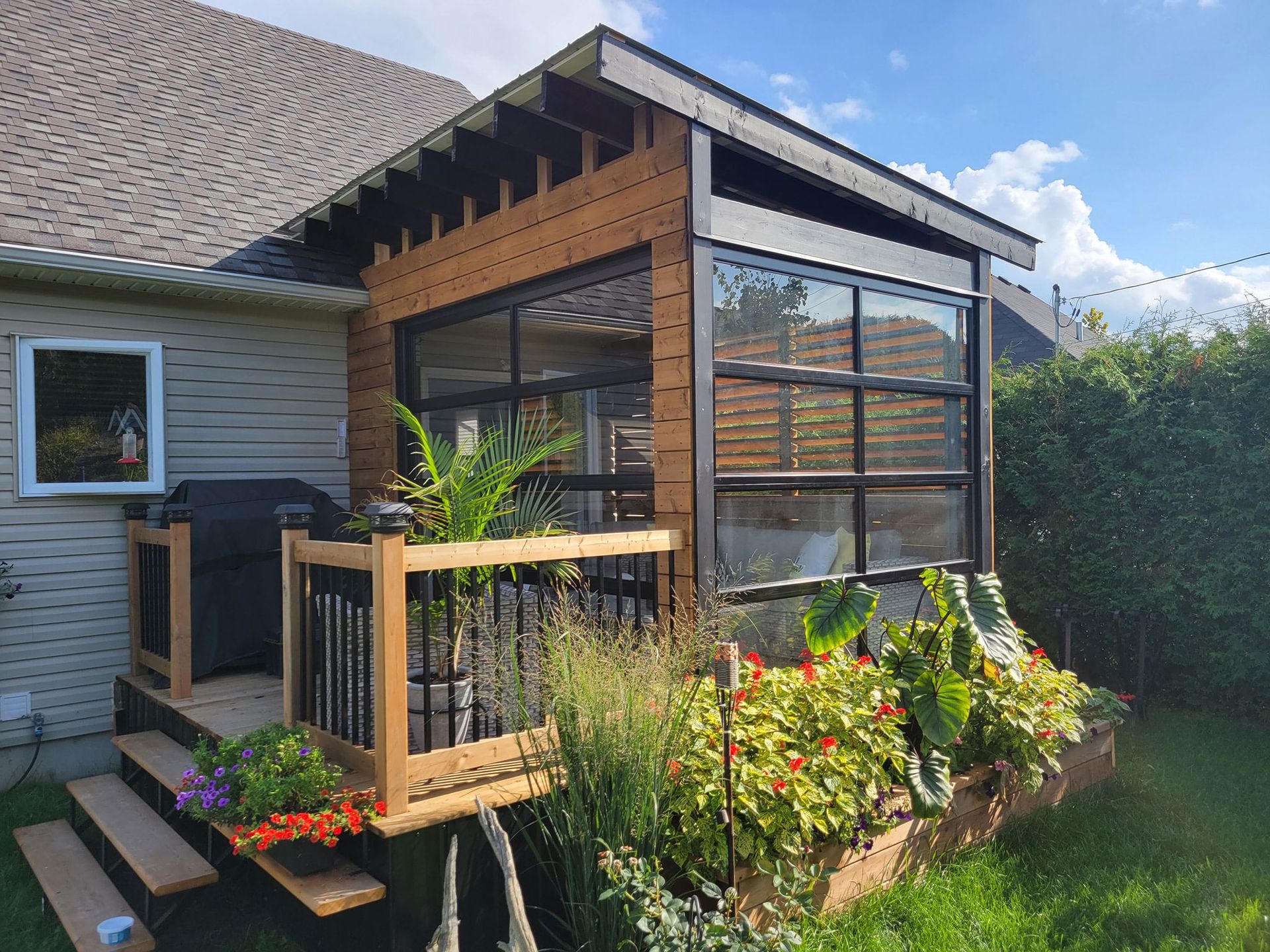 Glass-panel sectional doors with black frames enclosing a wooden deck
