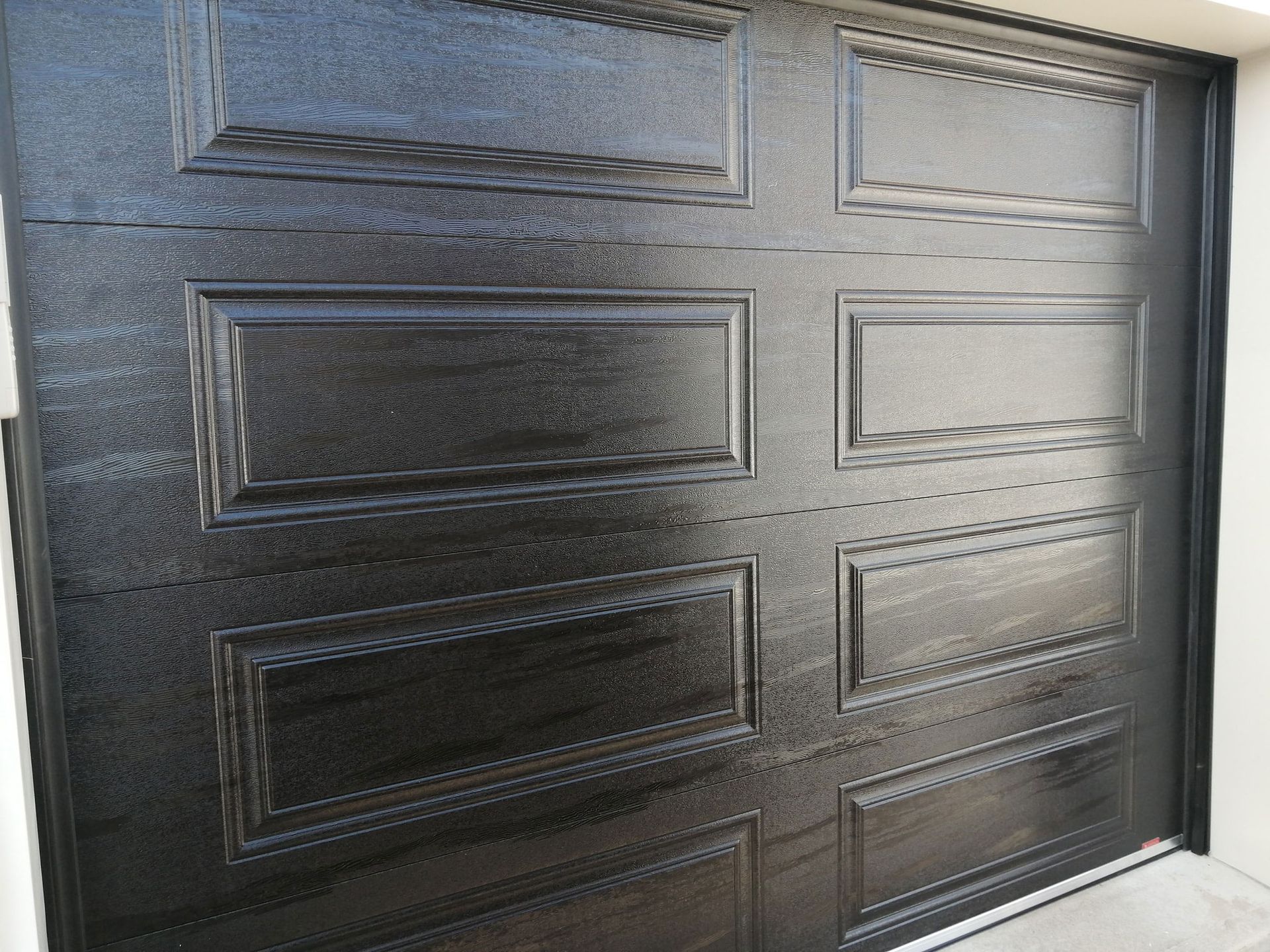 Close-up of textured rectangular panels on a dark garage door